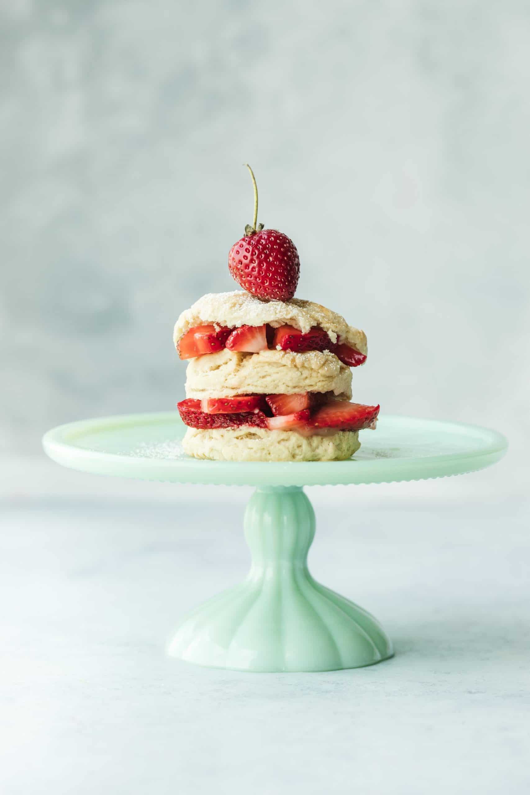 Erdbeertörtchen mit 2 Schichten Erdbeeren zwischen 3 Vanilleböden auf Porzellankuchenständer