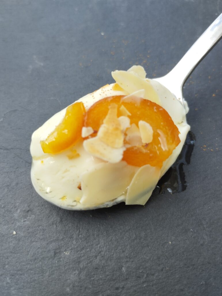 Pflanzliches Dessert mit Joghurt und eingelegten Orangenschalen auf Probierlöffel