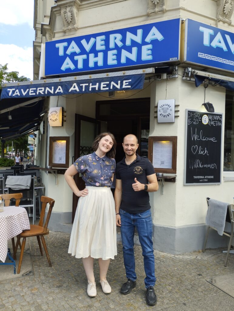 Anna Karle (Gastrofreude Consulting) und Panagiotis Drogidis (Taverna Athene) vor seinem Lokal in Berlin